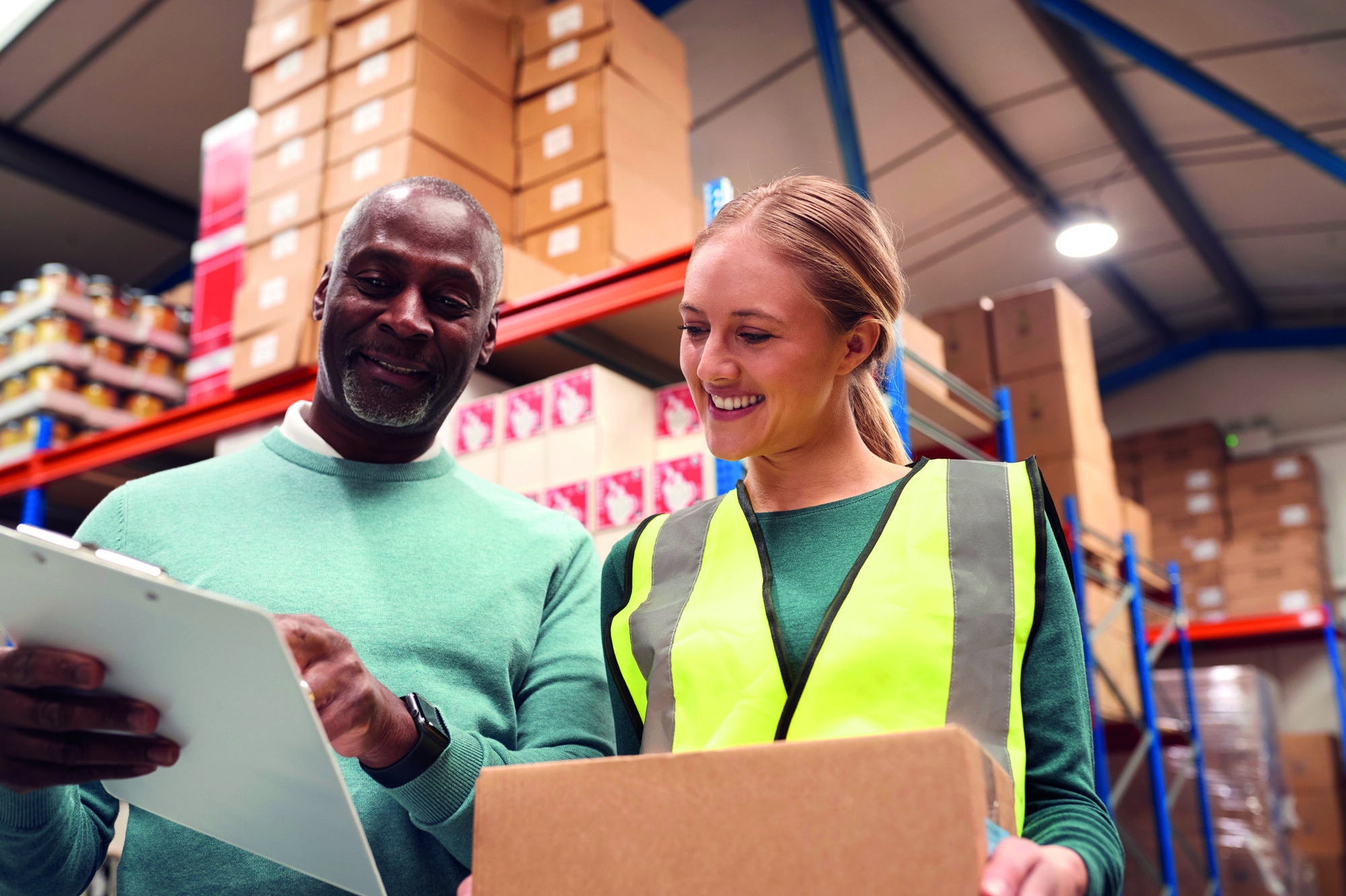Two people in a warehouse reading a clipboard