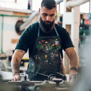 Male Worker Using Screen Printing Film And A Printing Machine In A Workshop