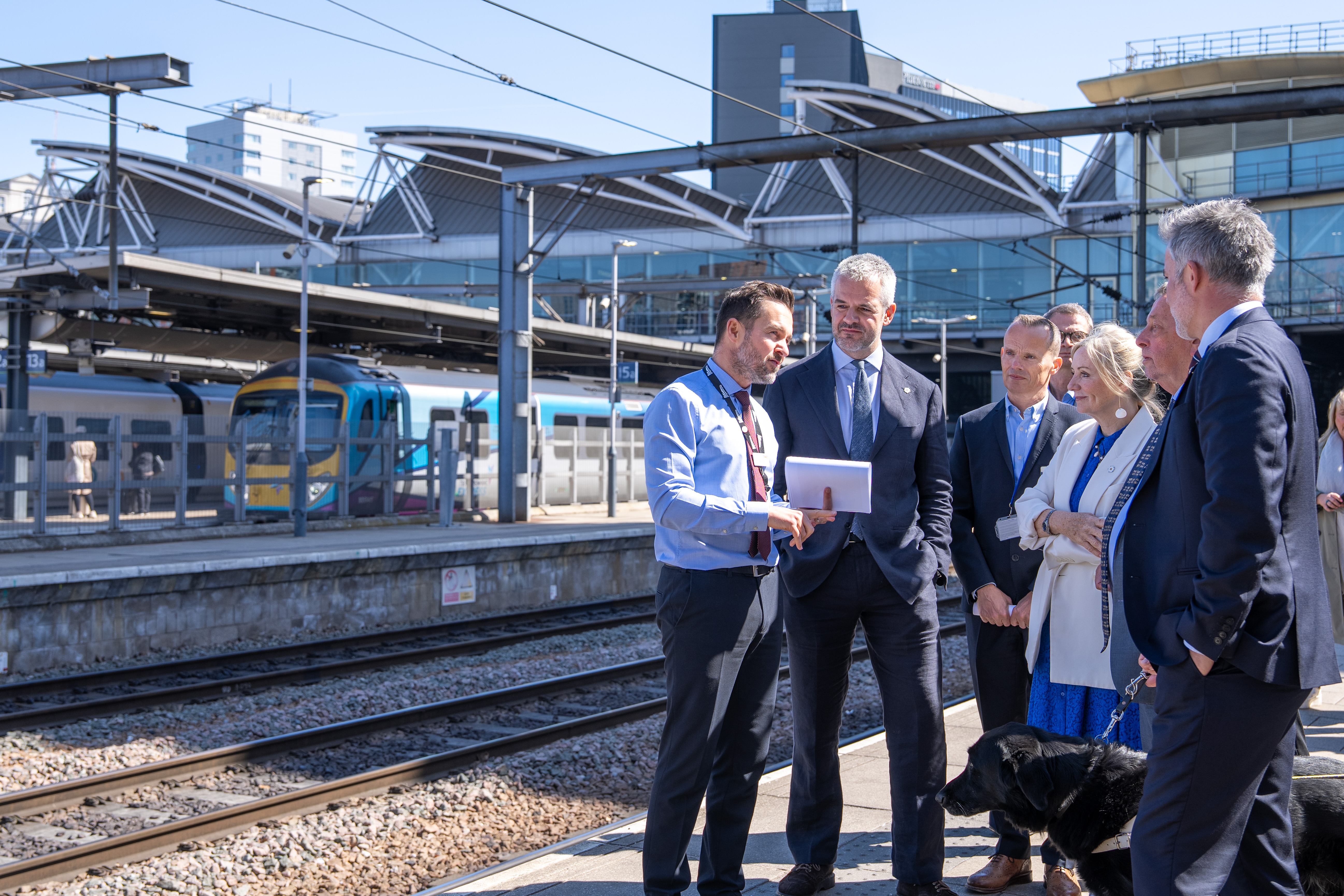 People speaking stood on a train platform