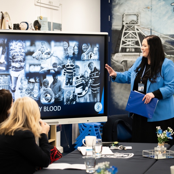 Educator points at screen to adult learners