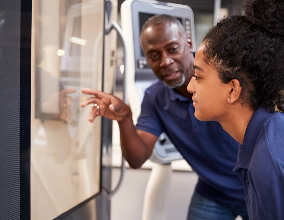 Engineer showing apprentice information on whiteboard