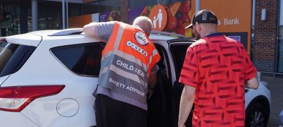 Man checking a child car seat is installed safely