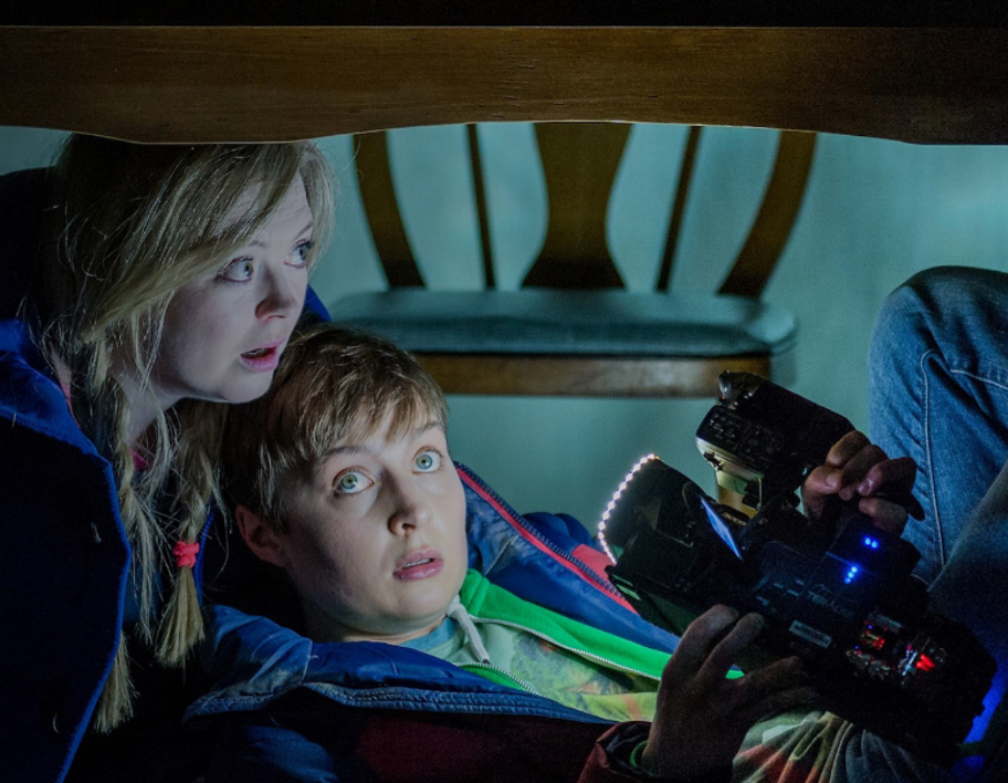 Actors on stage in theatre, with camera filming them