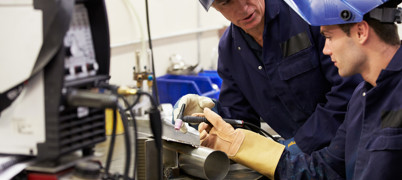 Engineer Teaching Apprentice To Use Welding Machine