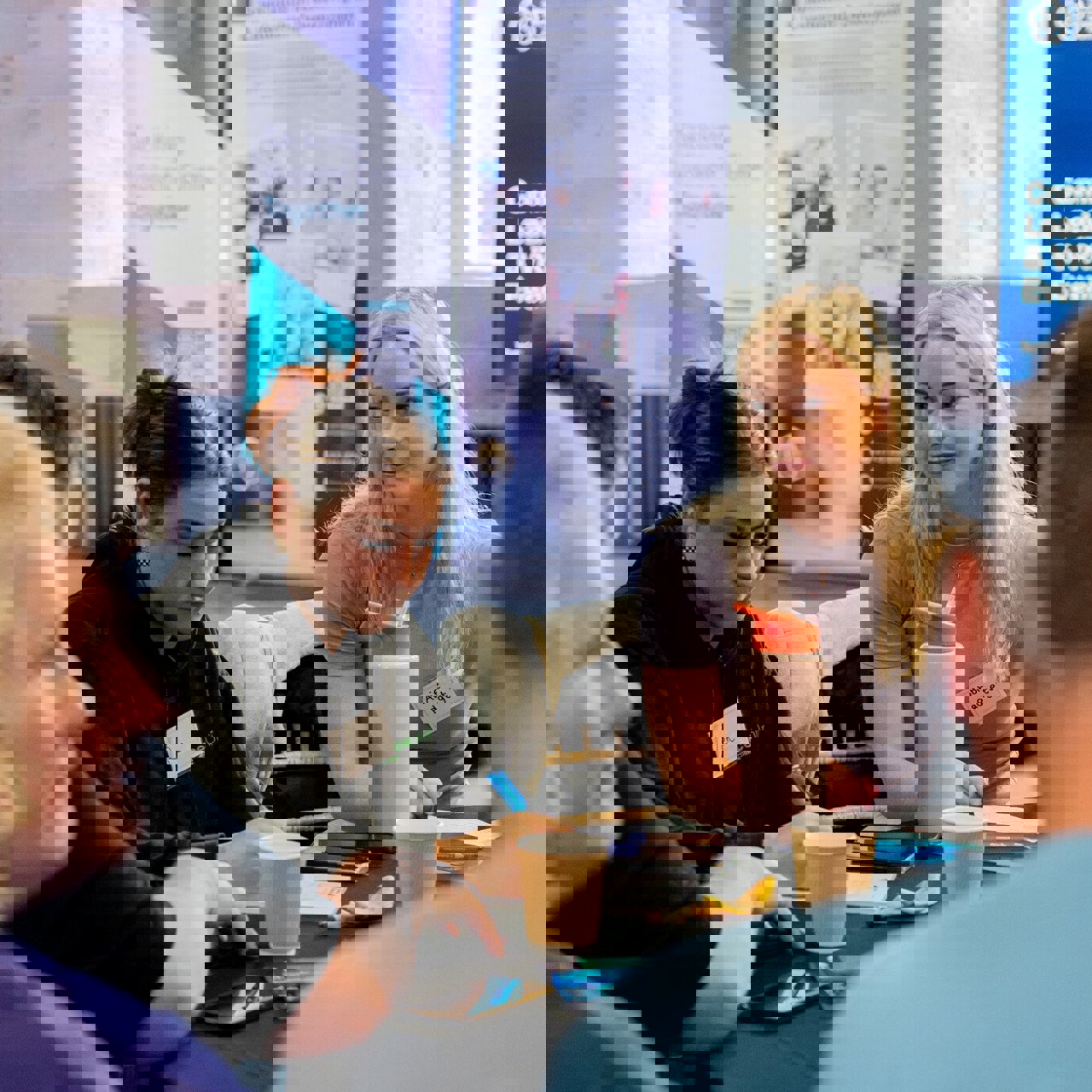 Young Women Sat At Table 