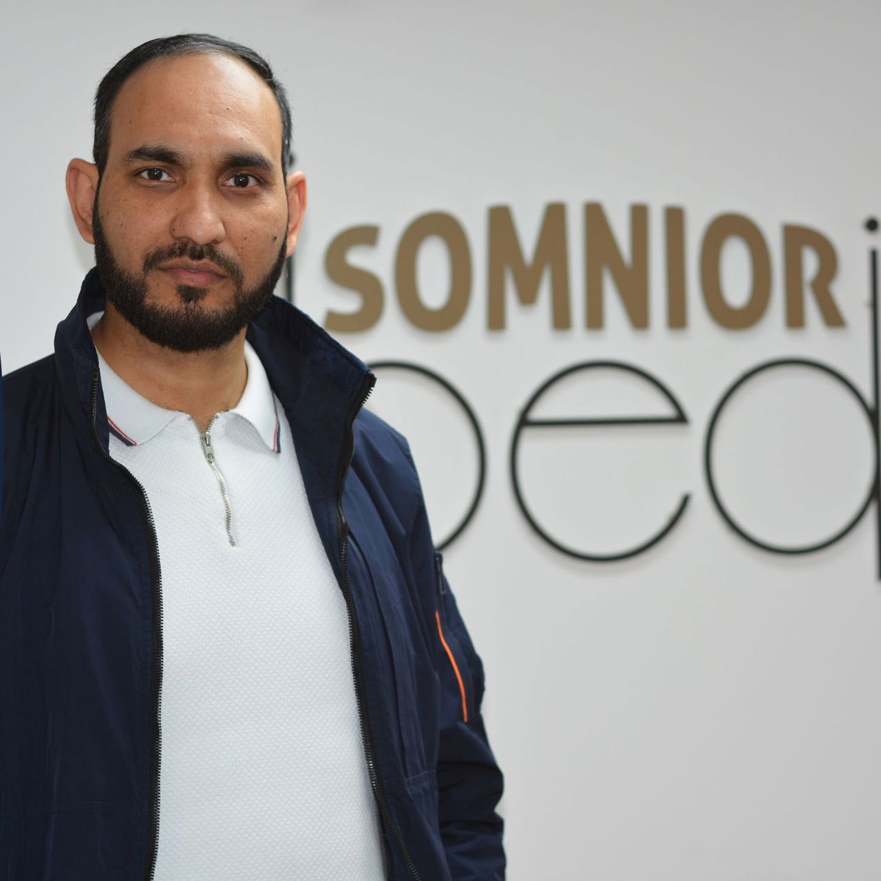 A man pictured in front of a Somnior Bed sign