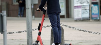 A man riding an e-scooter through the city