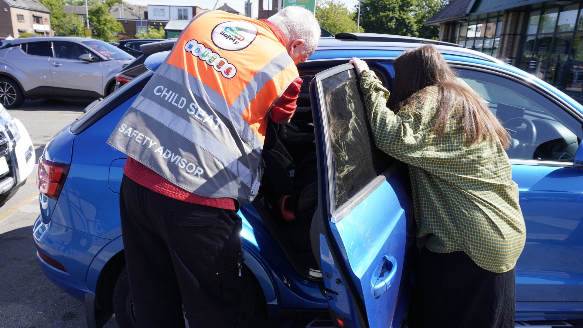 Man checking a child car seat is installed safely